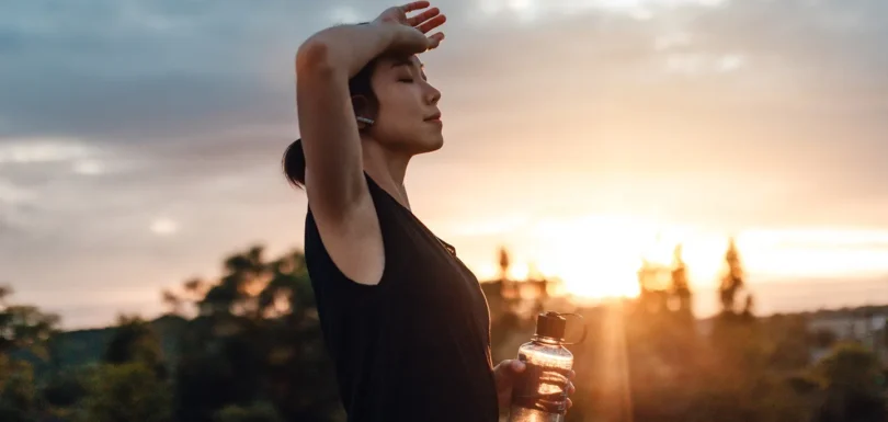 A woman practicing morning mindfulness and breathing exercises outdoors as part of daily habits to reduce stress naturally